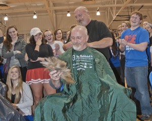 Students share in the fun as Village Barber Jim Sgro buzzes Mr. Schemrich.