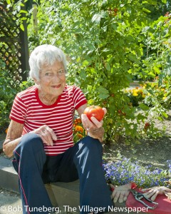 Barbara Fuller shows off the first of the season’s harvest in the resident garden.