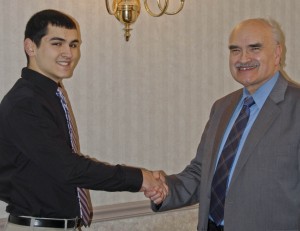 Pete Stamatis, left, of Avon High School, is congratulated by program producer Jim Mehrling for winning “Standout Scholar” honors on the Scholastic Games quiz program on WEOL radio (AM 930).